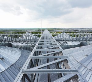 Agricultural Silos. Building Exterior. Storage and drying of grains, wheat, corn, soy, sunflower against the blue sky with white clouds