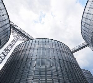 Agricultural Silos. Building Exterior. Storage and drying of grains, wheat, corn, soy, sunflower against the blue sky with white clouds